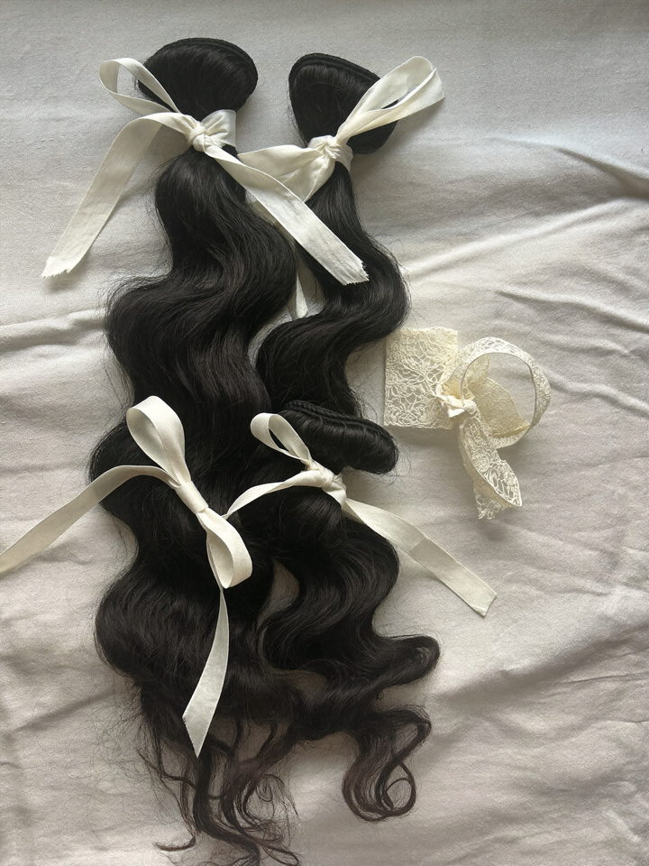 Three body wave bundles stacked beside a lace closure