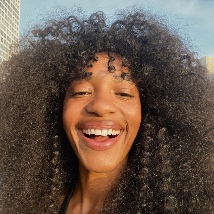 Customer selfie outdoors wearing a curly 360 lace unit